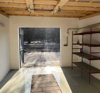 Garázsok a Pozsonyi-Dúbravka Agátová utcában vas polcokkal és nyitott ajtókkal.