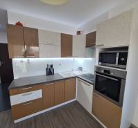 A kétszobás lakás konyhája fa dekor padlóval és modern készülékekkel.