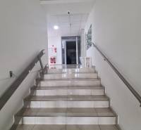 Fehér falú és csempézett padlójú lépcső vezet a kétszobás lakás bejáratához.