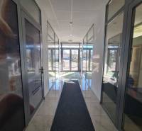 Világos folyosó üvegajtókkal és márványpadlóval Komáromban, alkalmas 2 szobás lakás számára.