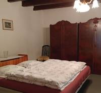 Hálószoba családi házban fa mennyezettel, antik szekrénnyel és klasszikus csillárral.