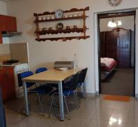 Étkező sarok és konyha családi házban polccal és mennyezeti ventilátorral.