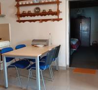 Családi ház étkezője edényeknek szánt polcokkal és asztallal, kék székekkel.