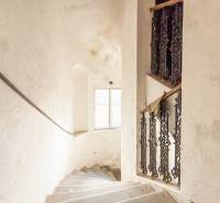 Családi ház lépcsője ablakkal és díszes korláttal, fehér fal patinával.