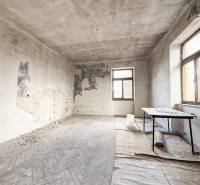 Elhagyatott szoba sérült falakkal és fa dekorációjú padlóval egy családi házban.