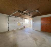 Raktárak és csarnokok betonpadlóval, fa mennyezettel és nagy garázskapukkal.