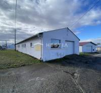 Raktárak és csarnokok Rybkóban füves környezettel felhős ég alatt.