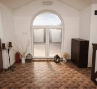 Belső vendéglátóipari terek díszítő elemekkel, csempézett padlóval és nagy íves ablakkal.