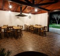 Gasztronómiai terek fa mintázatú padlóval, fa asztalokkal és kilátással a kertre.