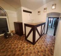 Vendéglátóhely belső tere pulttal, fa dekorációjú padlóval és fogassal.