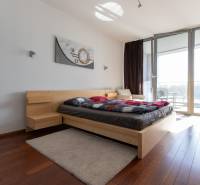 Hálószoba egy kétszobás lakásban fa dekor padlóval és tágas ablakokkal.