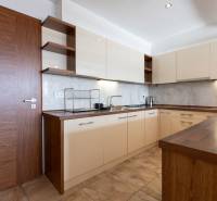 Konyha egy kétszobás lakásban világos szekrényekkel és fa dekorációjú padlóval.