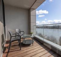 Erkély egy 2 szobás lakásban, kilátással a folyóra, fa dekorációjú padlóval.