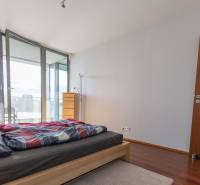 Hálószoba egy kétszobás lakásban fa dekoros padlóval és erkéllyel.