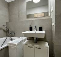 Fürdőszoba káddal és mosdóval egy kétszobás lakásban kerámia csempékkel.