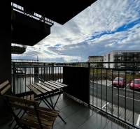 Erkély egy kétszobás lakásban Fehértemplomban, kilátással a parkolóra és az égre.