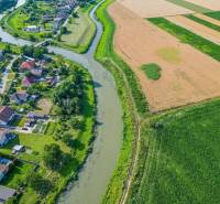 Feketevíz községgel és mezőkkel körülvett folyó mezőgazdasági és erdőterületekkel.