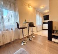 A kétszobás lakás belső tere fa dekor padlóval, bárszékekkel és dekorációkkal.