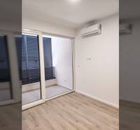 Szoba családi házban légkondicionálóval, fa dekoros padlóval és teraszra nyíló tolóajtókkal.