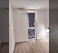 Szoba családi házban ablakkal, légkondicionálóval és fa dekorációjú padlóval.