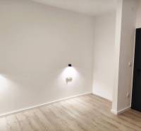 Családi ház fehér falakkal, sötét ajtókkal és fa dekorú padlóval.