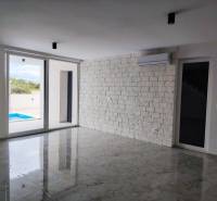 Nappali márványpadlóval és tolóajtókkal egy családi házban.