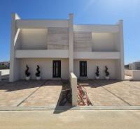 Családi ház a Mulo utcában, Vrsi-ben, burkolt sétánnyal és dekoratív növényekkel.