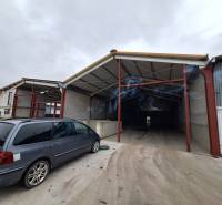 Raktárak és csarnokok a Strojnícka utcában, Eperjesen, parkoló járművekkel a bejárat előtt.