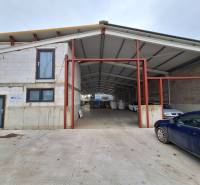 Raktárak és csarnokok a Strojnícka utcában, Eperjesen, egy autóval az épület előtt.