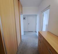 Folyosó egy 3 szobás lakásban beépített szekrénnyel és fa dekorációjú komóddal.