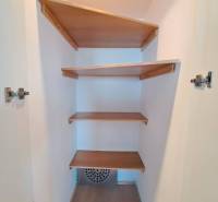 Beépített polcokkal ellátott gardrób egy négy szobás lakásban, fa dekor padlóval.