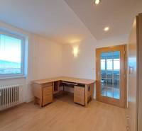 Dolgozószoba egy négy szobás lakásban, fa mintázatú padlóval és íróasztallal.