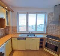 Konyha egy 4 szobás lakásban, fa dekor padlóval és kilátással a városra.