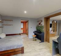 Szoba családi házban zongorával, ággyal és fa dekorációjú padlóval.