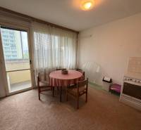 Konyha egy háromszobás lakásban étkezőasztallal, elektromos tűzhellyel és erkéllyel.