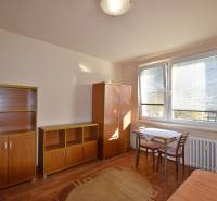 Garzonlakás bútorokkal, asztallal és székekkel, kiegészítve fa dekorációjú padlóval.