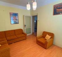 Nappali egy családi házban narancssárga bútorokkal és fa dekorációjú padlóval.