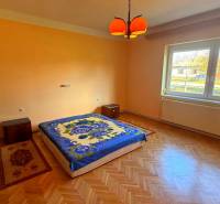 Hálószoba egy családi házban, fa dekor padlóval és narancssárga falakkal.