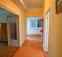 Egy családi ház folyosója fa dekorációjú padlóval és egy képpel a falon.