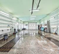 Belső mosócsarnok nedves padlóval és mennyezeti fénycsövekkel.