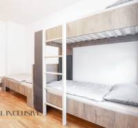 Emeletes ággyal és fa dekorációjú padlóval rendelkező belső tér egy épületben.