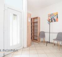 Az épület belseje bejárati ajtóval, csempével, polccal, két székkel és fogassal.