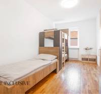 Hálószoba belső tér egy épületben, ágyakkal és fa dekorációjú padlóval.