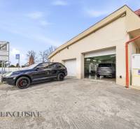 Épület Dunaszerdahelyen, autókkal a garázsok előtt és közlekedési táblákkal.