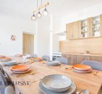 Konyha az épületben, fa szekrények, nagy asztal fa dekor padlóval.