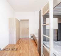 Emeletes ággyal, szekrényekkel és fa dekorációjú padlóval berendezett belső tér.