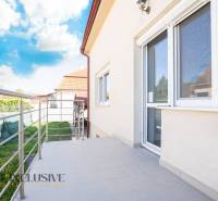 Épület Dunaszerdahelyen terasszal és korláttal, égbolt felhőkkel.