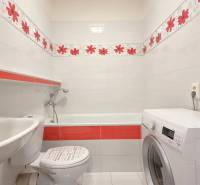 Fürdőszoba káddal, mosdóval és mosógéppel egy kétszobás lakásban.