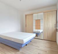 Kétszobás garzon ággyal, beépített szekrénnyel és fa dekoros padlóval.