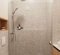 A négy szobás lakás fürdőszobája modern zuhanyzóval és tárolóhelyekkel.